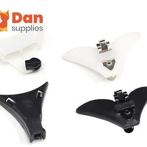 May include: Four hair clips, two white and two black. The white clips have a silver metal clasp. The black clips have a black metal clasp. The clips are shaped like a fish tail.