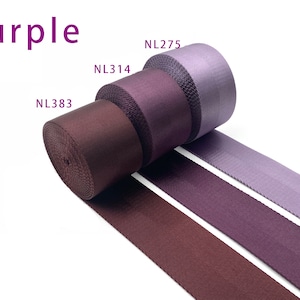 May include: Three rolls of purple nylon webbing tape arranged in a row. The rolls are labeled NL383, NL314, and NL275, showing shades ranging from deep dark purple to a lighter lavender tone. The text Purple is displayed in the upper left corner.