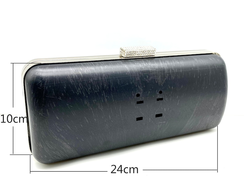 Pu&ograve; includere: Una pochette nera con cornice argentata e chiusura in strass. La pochette misura 24 cm per 10 cm.