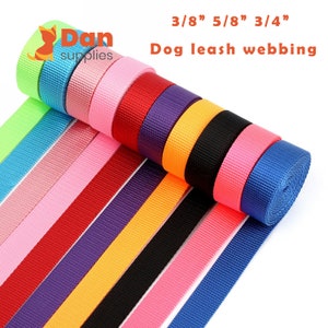 May include: A selection of colorful dog leash webbing rolls in various colors, including blue, pink, red, and black. The image includes text indicating the widths available: 3/8", 5/8", and 3/4". The product is labeled "Dog leash webbing".