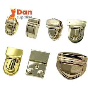 May include: Assortment of gold-toned metal clasps and closures for bags, purses, and other accessories. The clasps are in various shapes and sizes, including rectangular, oval, and shield-shaped.