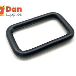 Könnte beinhalten: Eine mattschwarze, rechteckige Metallschlaufe mit abgerundeten Ecken, einer glatten Oberfläche und einer soliden Konstruktion. Das Logo von Dan supplies ist in der oberen linken Ecke zu sehen, mit einem orangefarbenen Katzensymbol und dem Text Dan supplies.