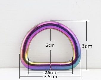 May include: A rainbow-colored metal D-ring with a 2 inch inner diameter and a 3 inch outer diameter. The ring is 2.5 cm wide and 3.5 cm long.