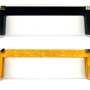 May include: Two picture frames, one black and one wood, with gold corner accents. Both frames have a simple, rectangular design.