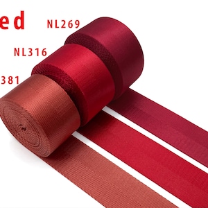 May include: Three rolls of red nylon webbing tape arranged in a row, each featuring a distinct shade of red. The rolls are labeled with the text NL269, NL316, and NL381, with the word Red displayed in the upper left corner of the image.