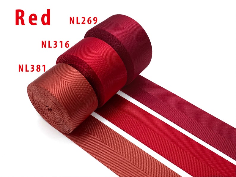 May include: Three rolls of red nylon webbing tape arranged in a row, each featuring a distinct shade of red. The rolls are labeled with the text NL269, NL316, and NL381, with the word Red displayed in the upper left corner of the image.