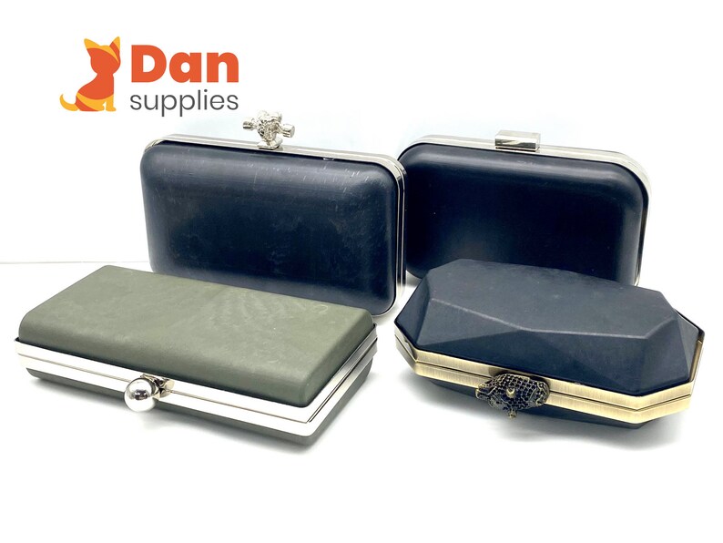 May include: Three different styles of black and green clutches with silver and gold hardware. The clutches have a variety of textures and shapes.