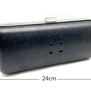 Pu&ograve; includere: Una pochette nera con cornice e chiusura in metallo argentato. La pochette misura 24 cm di lunghezza e 10 cm di altezza.