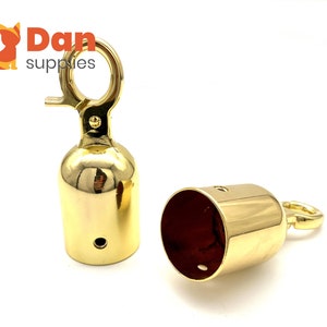 May include: Two gold metal end caps with a hook on one side. The end caps are designed to be used on the ends of ropes or cords.