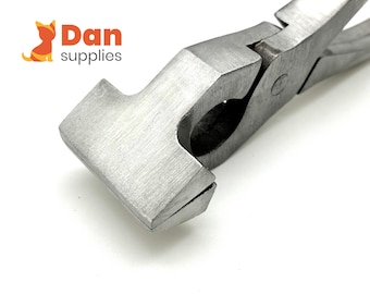 Puede incluir: Primer plano de unas pinzas de metal plateadas con una mordaza plana y rectangular. Las pinzas están diseñadas para crimpado de metal.