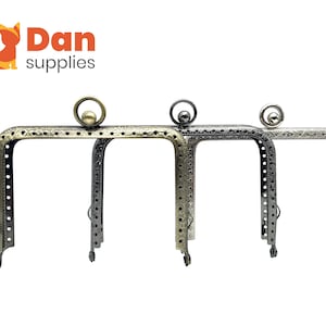 May include: Three metal purse frames in different finishes: antique brass, silver, and nickel. Each frame has a decorative design and a round top.