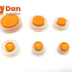 May include: Six orange and clear plastic bottle stoppers of varying sizes.