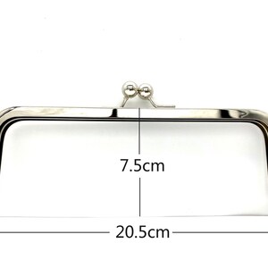 May include: Silver-toned metal purse frame with two round metal clasps. The frame measures 7.5 inches wide and 20.5 inches long.