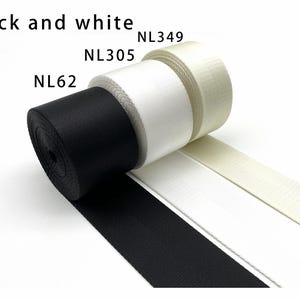 May include: Three rolls of woven webbing tape in black, white, and off-white, labeled NL62, NL305, and NL349 respectively. The text Black and white is printed at the top. Each roll features a tight, durable weave texture and a flat, smooth finish.