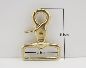 May include: A gold-toned metal clasp with a rectangular loop and a spring-loaded hook. The clasp measures 6.5 cm in height and 3.8 cm in width.