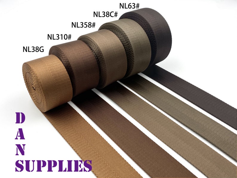 May include: Five rolls of brown webbing with herringbone pattern. The rolls are labeled with the following product codes: NL38G, NL310#, NL358#, NL38C# and NL63#. The text "DAN SUPPLIES" is printed in purple below the rolls.