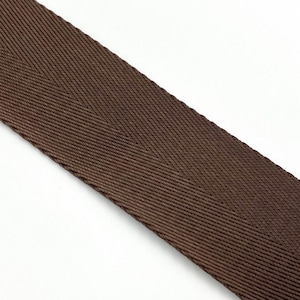 May include: A close-up of brown woven webbing with a herringbone pattern.