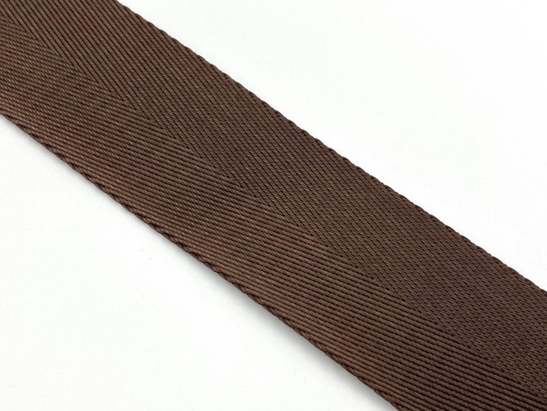 May include: A close-up of brown woven webbing with a herringbone pattern.