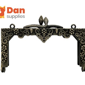 May include: Antique gold-toned metal purse frame with a decorative floral design and two snake-shaped handles.