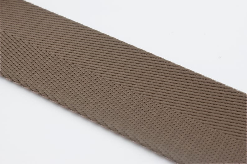 May include: A close-up of brown woven ribbon with a herringbone pattern.