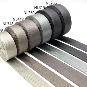 May include: A variety of gray, black, and silver woven webbing rolls with the product codes NL299, NL348, NL448, NL250, NL315, and NL266.