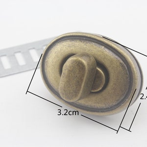 May include: Antique brass oval-shaped turn lock clasp with a 3.2 inch by 2.4 inch measurement.