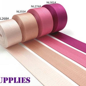 May include: Assortment of colorful rolls of webbing in shades of pink and purple. The rolls are labeled with numbers, and the text "DAN SUPPLIES" is visible in purple. The webbing is displayed on a white background.