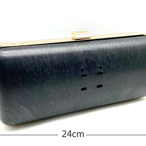Pu&ograve; includere: Una pochette nera con cornice e chiusura in metallo dorato. La pochette misura 24 cm di lunghezza e 10 cm di altezza.