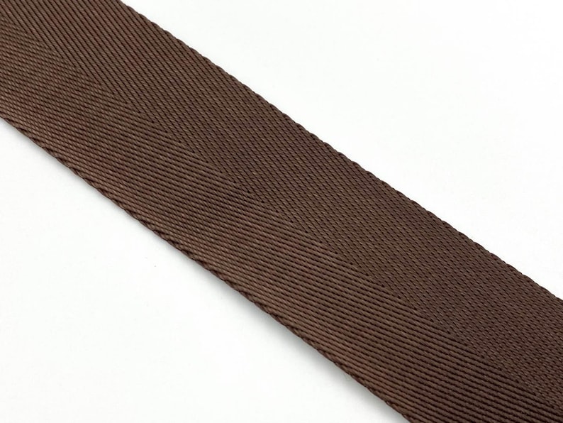 May include: A close-up of brown woven webbing with a herringbone pattern.