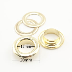 Könnte beinhalten: Goldene Metallösen mit einem Innendurchmesser von 12 mm und einem Außendurchmesser von 20 mm.