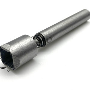 May include: A silver metal tool with a spring and a square head. The square head measures 12 mm across.
