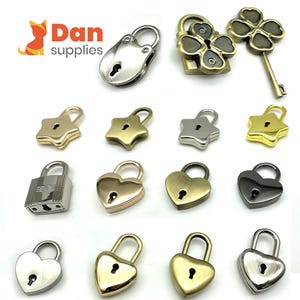 May include: Assortment of small decorative locks in various shapes and finishes, including heart, star, and clover shapes. The locks are made of metal and come in silver, gold, and black.