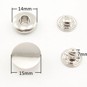 Peut inclure: Boutons pression en métal argenté, l'un de 14 mm de diamètre et l'autre de 15 mm de diamètre. Le plus petit bouton pression a un poteau de 7 mm de haut.