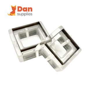 Könnte beinhalten: Zwei transparente, quadratische Möbelprotektoren aus Kunststoff mit dunkelbraunem Rand. Die Protektoren sind gestapelt und abgewinkelt, um ihr Design zu zeigen. Das Logo "Dan supplies" ist oben links sichtbar.