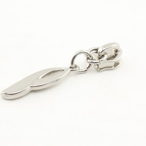 May include: Silver zipper pull with a decorative, elongated, curved shape. The pull is attached to a silver chain.