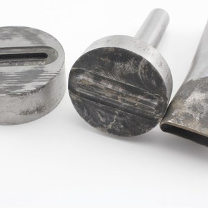 May include: Three metal leather hole punch tools. The tools are used to create holes in leather for stitching or other purposes. The tools are made of metal and have a silver finish. The tools are in various sizes and shapes.