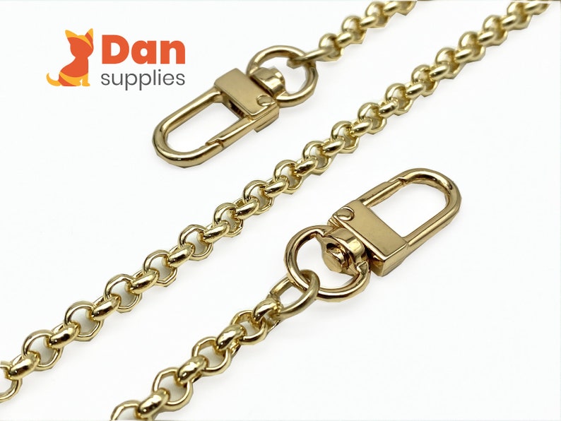 Op de afbeelding: Gouden ketting met twee gouden karabijnhaken. De ketting is ongeveer 45 cm lang en heeft een delicaat, gekoppeld ontwerp.
