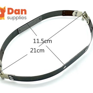 Könnte beinhalten: Ein silbernes Metall-Stirnband mit zwei verstellbaren Scharnieren. Das Stirnband ist 21 cm lang und 11,5 cm breit.