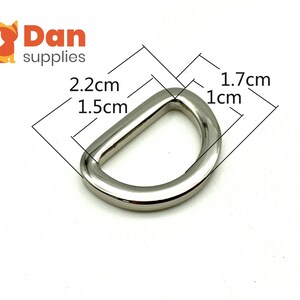May include: Silver metal D-ring with measurements: 2.2 cm x 1.5 cm x 1.7 cm x 1 cm.