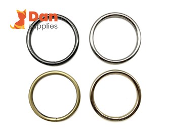 May include: Four metal rings in different finishes: black, silver, gold, and brass. The rings are all the same size and are perfect for attaching to bags, keychains, or other accessories.