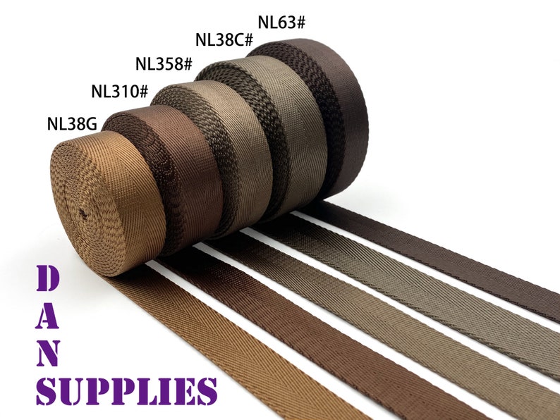 May include: Five rolls of brown webbing with different shades of brown. The rolls are labeled with the following codes: NL38G, NL310, NL358, NL38C, and NL63. The text "DAN SUPPLIES" is printed in purple below the rolls.