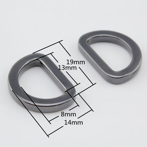 May include: Two silver-toned metal D-rings with measurements in millimeters. The larger ring measures 19mm by 13mm, and the smaller ring measures 14mm by 8mm.