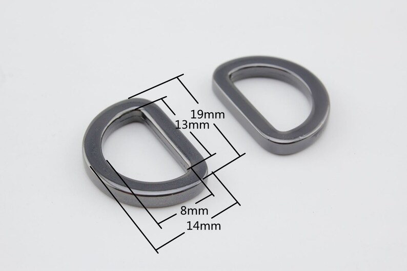 May include: Two silver-toned metal D-rings with measurements in millimeters. The larger ring measures 19mm by 13mm, and the smaller ring measures 14mm by 8mm.