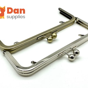 May include: Two purse frames, one silver and one gold, with two round metal clasps on each.