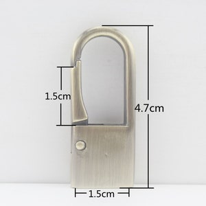 Puede incluir: Gancho para llavero de metal de color dorado antiguo con una abertura de 1,5 cm de ancho. El gancho mide 4,7 cm de largo y 1,5 cm de ancho.
