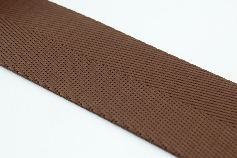 May include: Brown woven ribbon with a herringbone pattern.