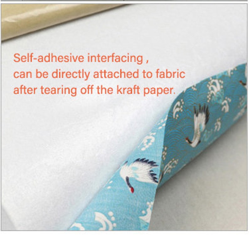 May include: White self-adhesive interfacing with a kraft paper backing. The interfacing is shown being applied to a blue fabric with a white crane pattern. The text on the image reads: "Self-adhesive interfacing, can be directly attached to fabric after tearing off the kraft paper."