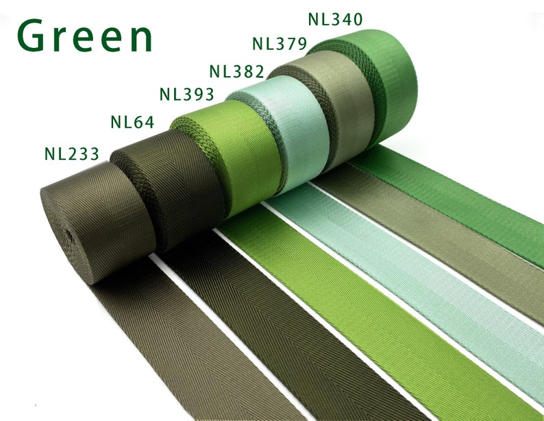 May include: Six rolls of woven nylon webbing in various shades of green, labeled NL233, NL64, NL393, NL382, NL379, and NL340. The fabric strips are arranged in a row, displaying a gradient from dark olive to light mint and bright grass green.