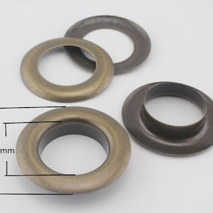 May include: Three antique gold metal grommets, two are 50mm in diameter and 30mm in width, and one is smaller.