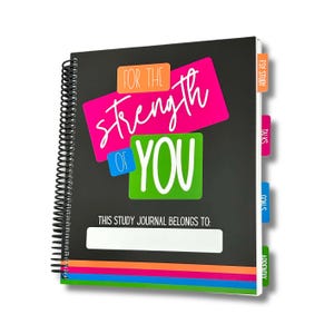 May include: A black spiral-bound study journal with the text "FOR THE Strength OF YOU" in white, pink, orange, and green. The journal has colorful tabs and a space to write the owner's name. A rainbow stripe design accents the bottom.